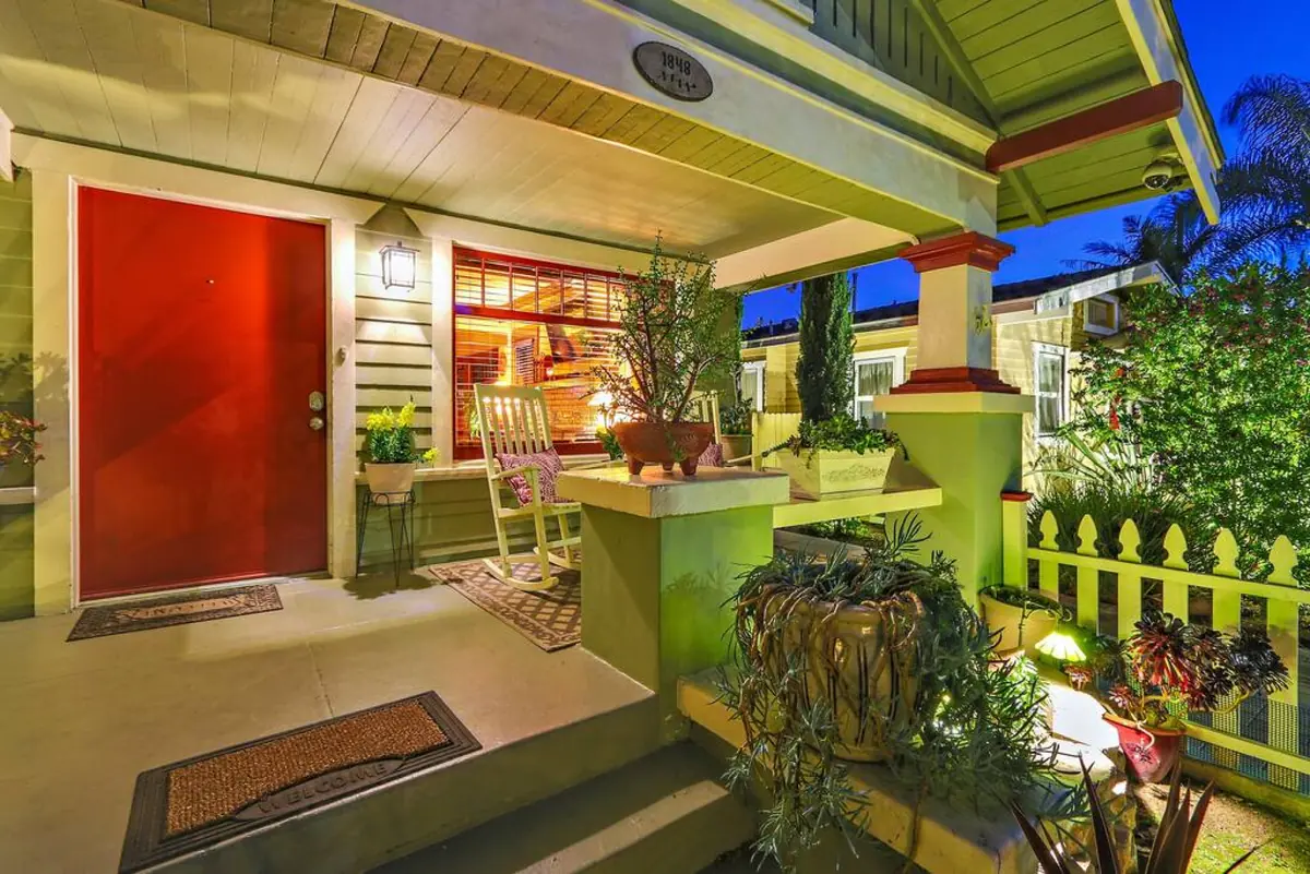 Front porch with rocking chair and the bungalow's red front door