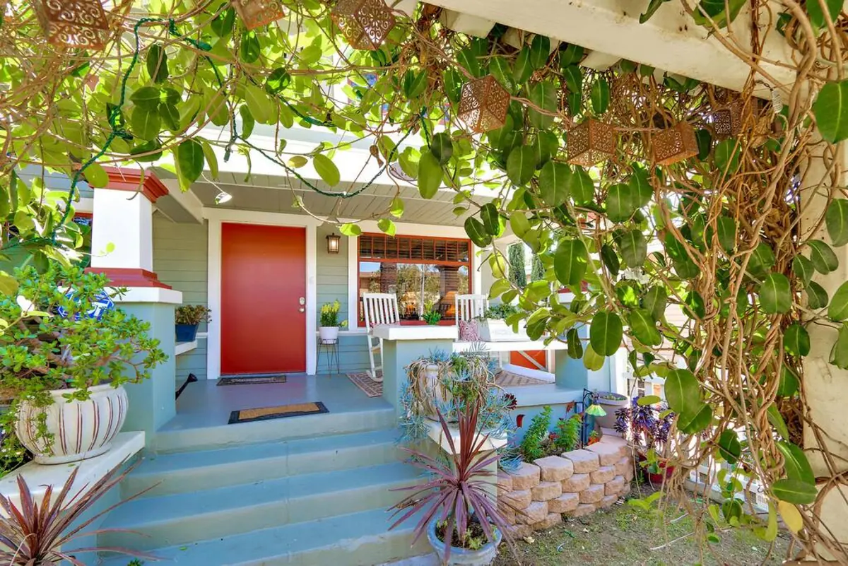 Vine-covered arbor leading to the front porch