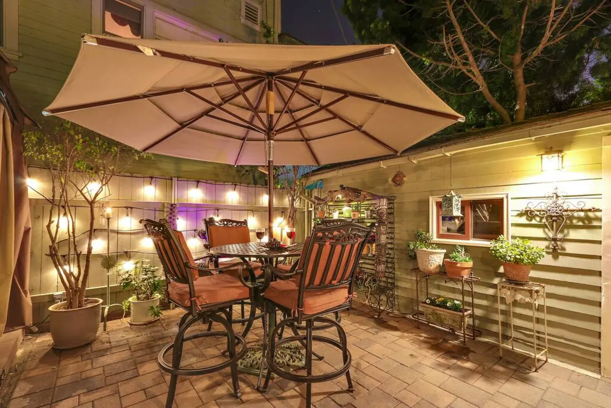 Patio dining table under string lights at dusk